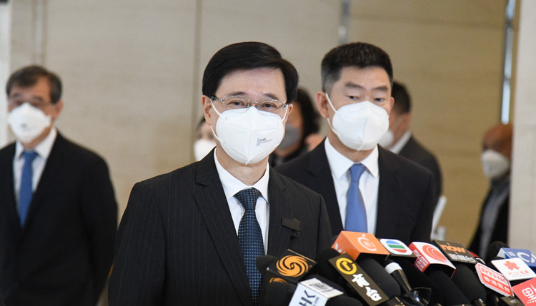 李家超今報(bào)名參選特首 ?馬不停蹄晤選委 收逾700張?zhí)崦? title=