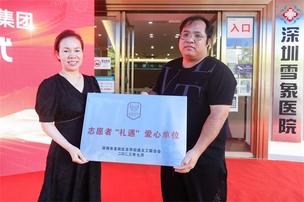 圖片2，吉華街道義工聯(lián)理事長(zhǎng)吳軍勇（右）為深圳雪象醫(yī)院院長(zhǎng)湯俊英授志愿者“禮遇”愛(ài)心單位牌匾.jpg