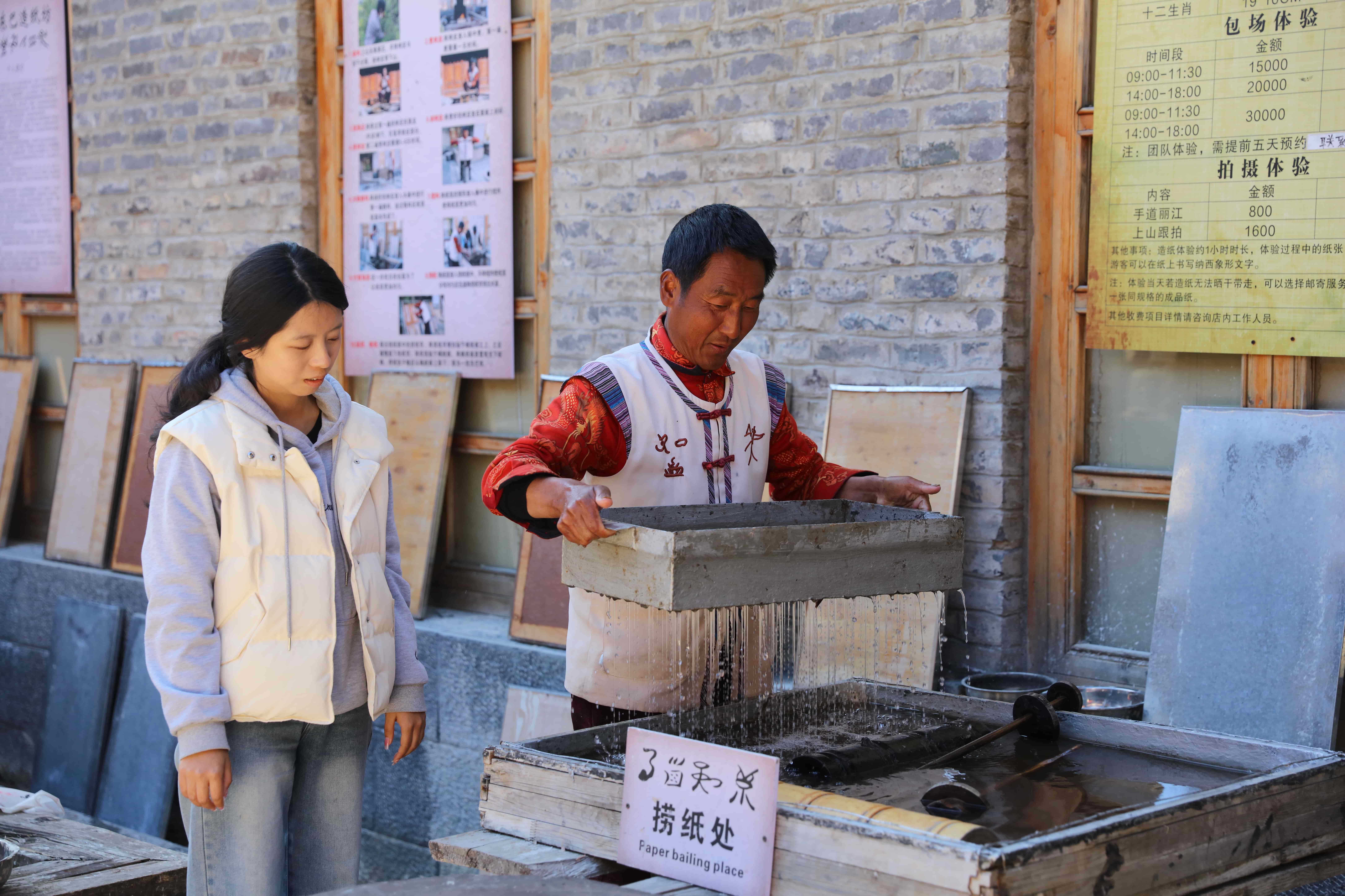圖4：東巴紙非遺傳承人和秀昌向游客展示造紙技藝 王冰 攝.JPG