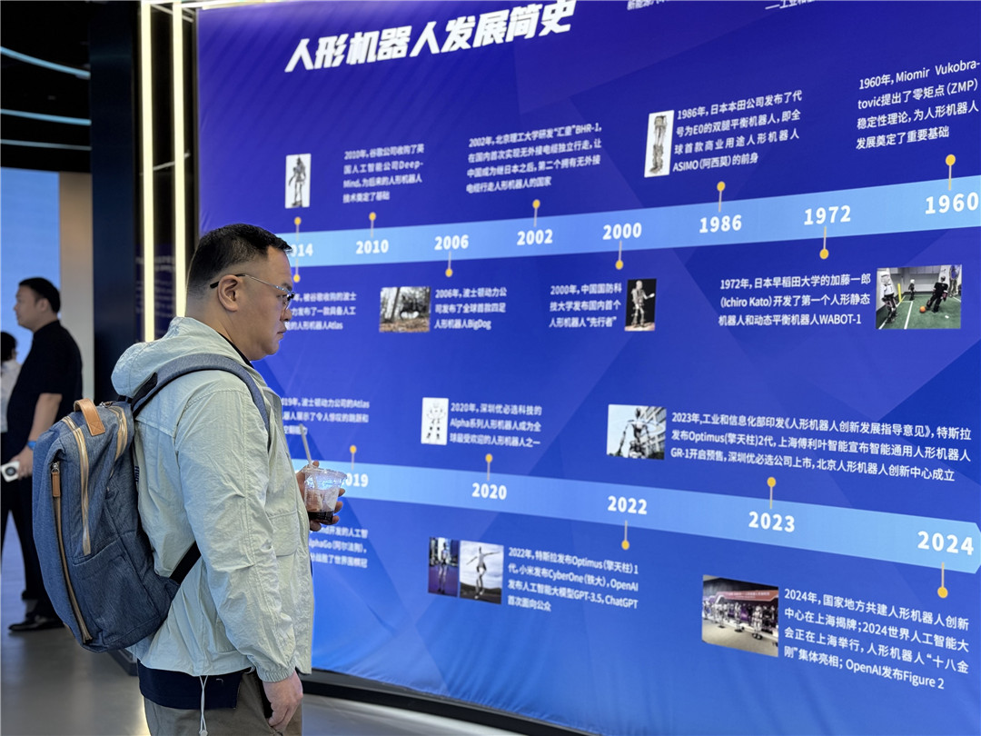 圖二：記者瀏覽人形機(jī)器人發(fā)展簡(jiǎn)史.jpg