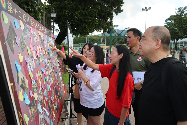 8月10日，第十八屆香港青少年軍事夏令營暨第十二屆香港大學(xué)生軍事生活體驗營閉營典禮在駐香港部隊新圍軍營舉行，圖為：學(xué)員家長觀看學(xué)員生活剪影和心愿卡片--攝影：易定.JPG